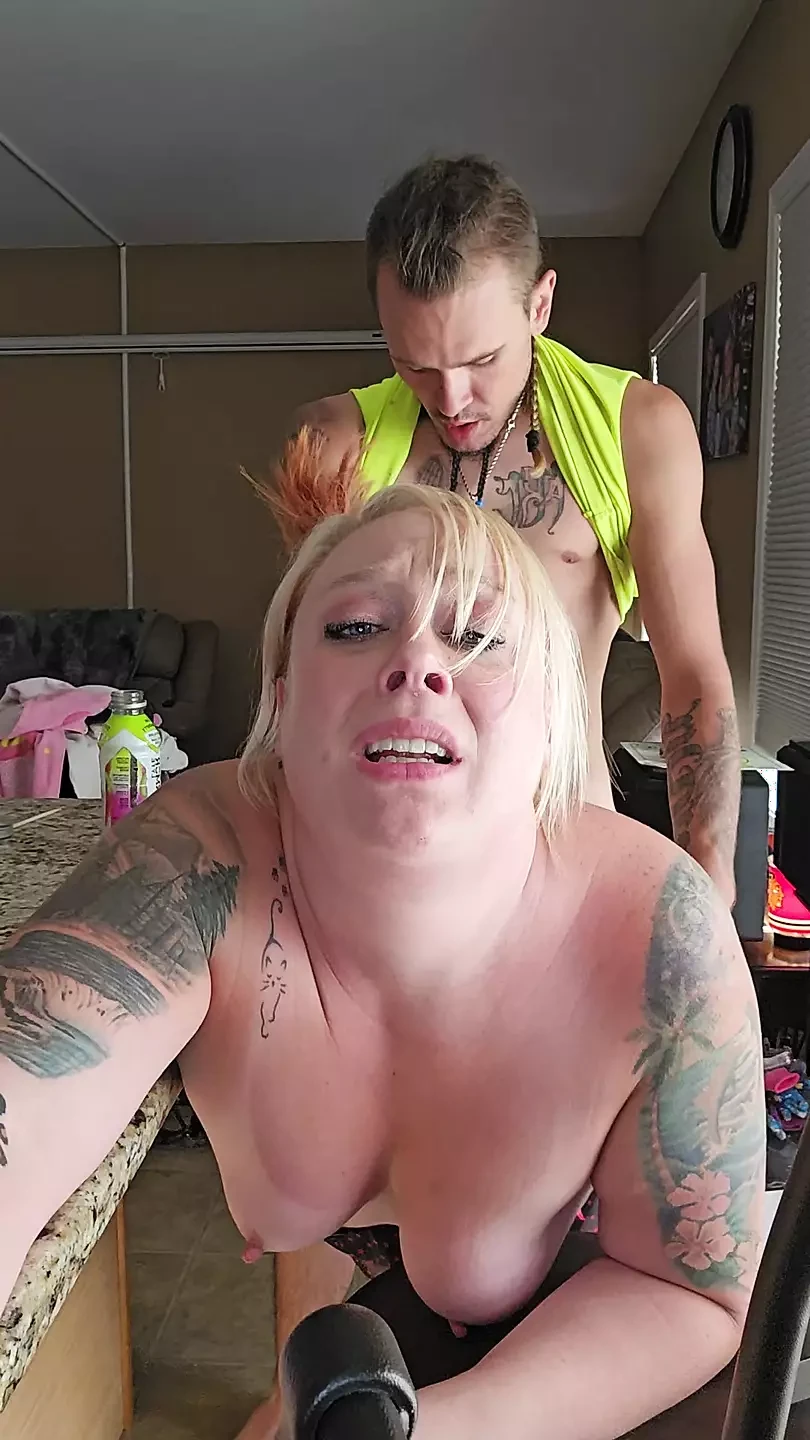 Husband sneaks in on wife doing dishes