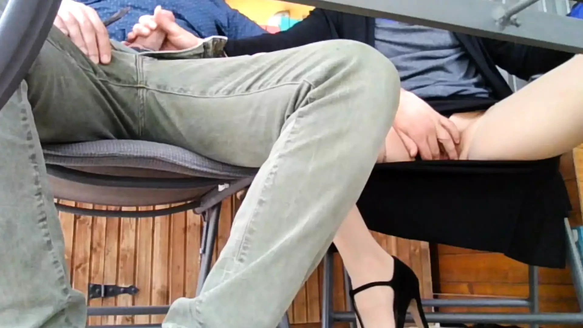 Under the table. The cheating wife invites the neighbor for a drink and  rides him