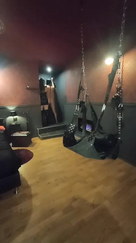 Mistress Acanthus raises her slave on a leash to the whip on the cross